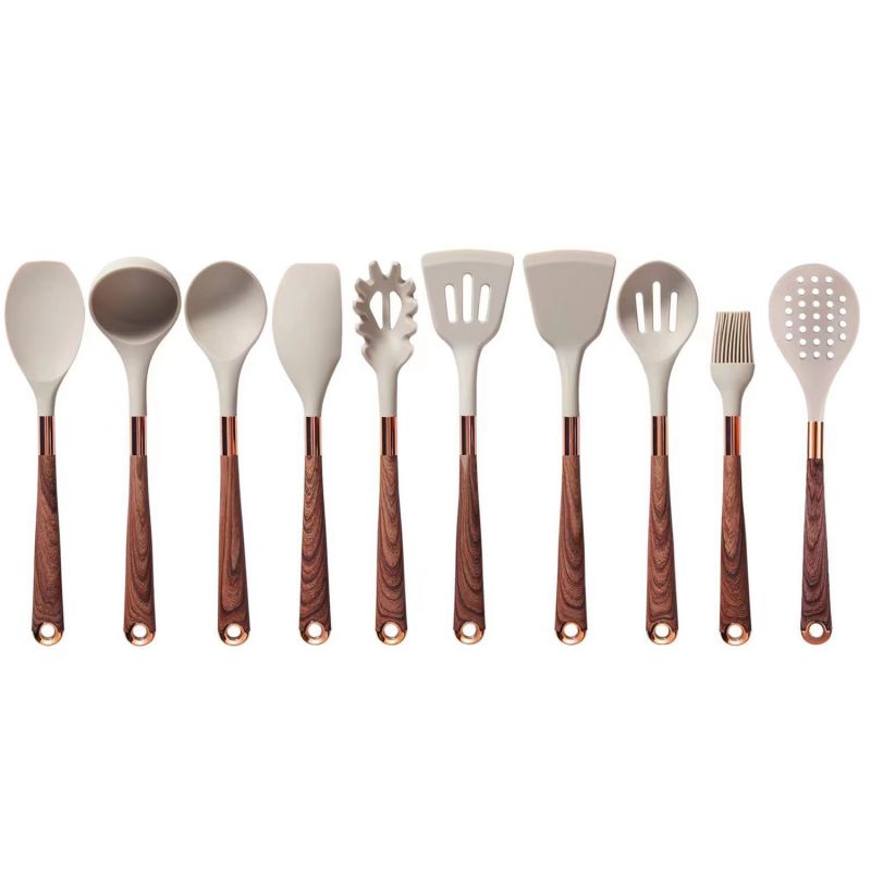 Dešimt virtuvės įrankių su šviesiai pilkais silikoniniais galais ir medinėmis rankenomis.