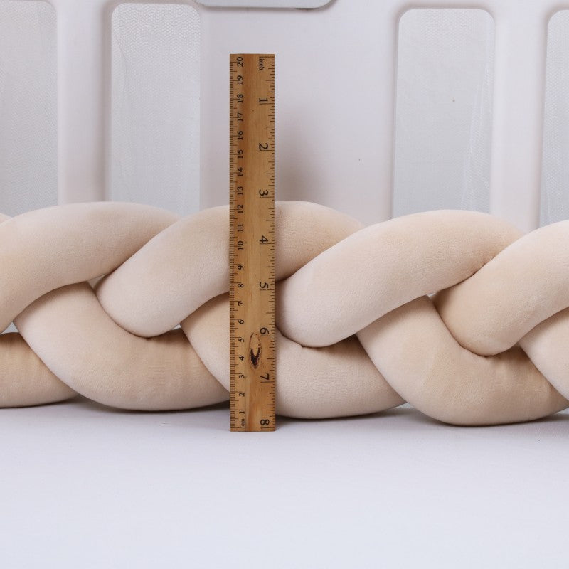 Šviesiai kreminės spalvos, minkšta, pintinė dekoratyvinė pagalvė.