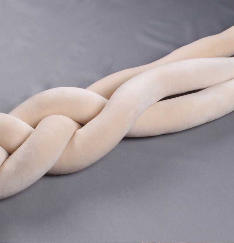 Šviesiai kreminės spalvos, minkštos tekstūros, susuktos formos dekoratyvinis elementas.