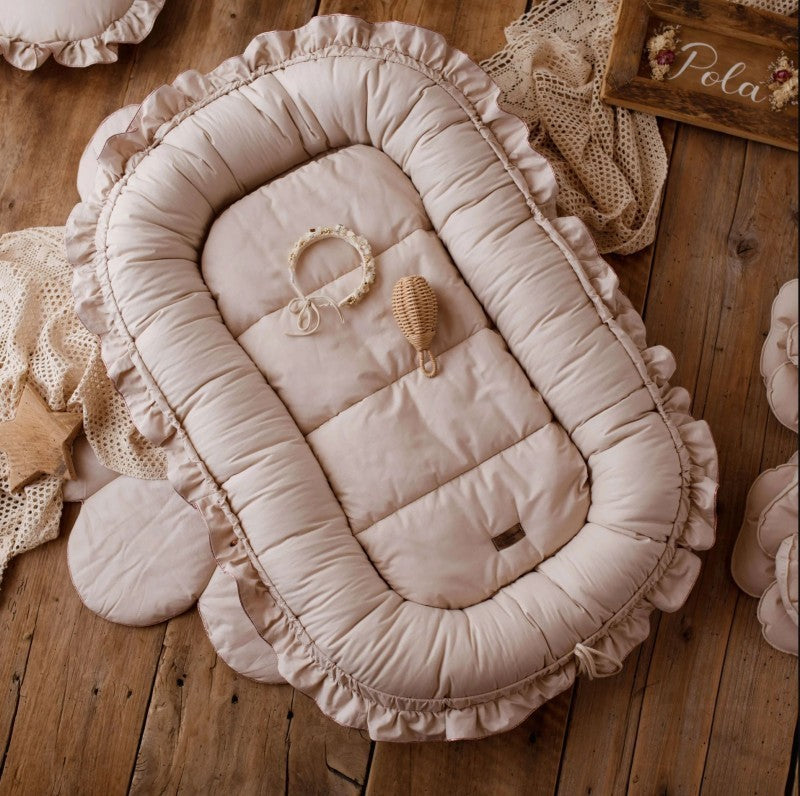 Šviesiai ruda, ovali lovelė su minkštu kraštu ir nėriniais.