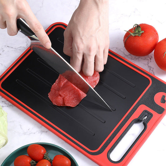 Juodas pjaustymo lentas su raudonu kraštu, ant jo pjaustomas raudonas mėsa.